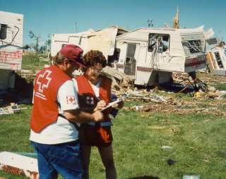 Red Cross Staffer Leslie Vryenhoek and amateur radio operator Darren Misik VE6ZZM compare notes at devastated campsite.