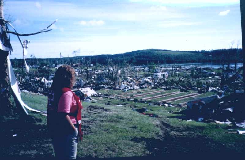 Red Cross worker views the damage in daylight.